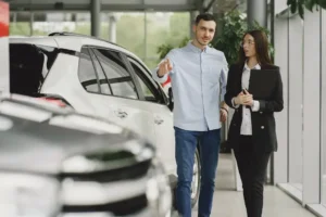 A man and woman looking at cars in a showroom.