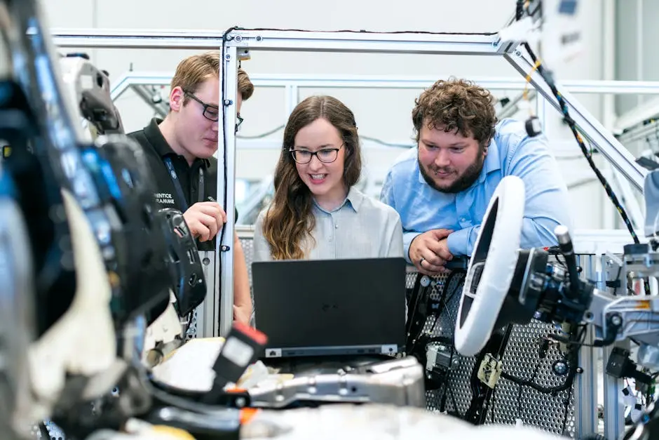 Team reviewing data on laptop in factory.