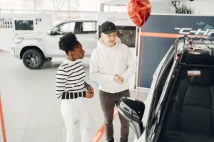 Two people discussing car in showroom.