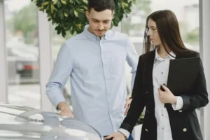 Man and woman discussing a car purchase.